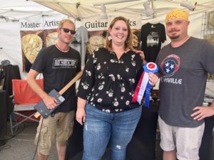 Dustin Headrick (left) and Michael Hunter of Nashville received the “Best Display” craft award from Dana Scott at the Fiddlers Jamboree Saturday.