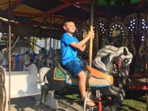 Youngster Enjoying Ride on Merry Go Round at DeKalb County Fair