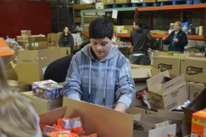 DeKalb West School Junior Beta Club member Karson Smallwood loads up a wheel barrow with catfish in a service project for the people served at Joseph's Foodhouse in Lebanon.