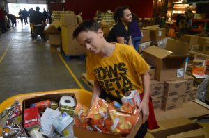 Kolton Slager loads up a wheel barrow with food at Joseph's Storehouse.