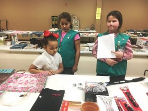 Girl Scouts assist child shopping during regifting event in 2018