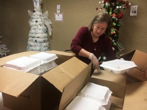 Darlene Tramel packing food trays for delivery