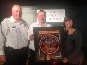 Lieutenant Dusty Johnson was named the 2018 Liberty State Bank Officer of the Year. County Fire Chief Donny Green (left) presented the award Saturday night at the annual banquet. Also pictured is Rhonda Caplinger of Liberty State Bank