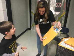 DWS teacher Whitney Brelje with literacy detective student in search of clues to sole a mystery during Family Literacy Night