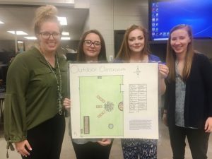 DCHS students Aubry Downey and Allison Young display the design they created which was chosen as the model for a new Outdoor Learning Space and Garden to be developed in May on campus at DCHS made possible through a $5,000 grant from the Lowe’s Toolbox for Education Foundation. Pictured: DCHS agriculture teacher and FFA advisor Lizzie Burrows (far left) Aubry Downey, Allison Young and DCHS math teacher Amy Fricks (far right)