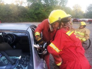 DeKalb Citizens Fire Academy participant and County Commissioner Jenny Trapp using jaws of life cutter tool to cut through post as part of the process in removing a car top. A procedure that would be exercised at a real world crash scene to gain access to a victim