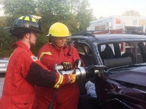 DeKalb Firefighter Matt Adcock gives Citizens Fire Academy participant Dana Scott instruction on using jaws of life cutter tool to cut through post as part of the process in removing a car top. A procedure that would be exercised at a real world crash scene to gain access to a victim