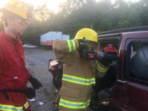 DeKalb Citizens Fire Academy participant and County Commissioner Beth Pafford using a jaws of life saw to remove the top of an SUV