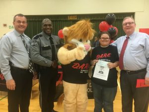 5th Grade DARE Graduation Overall Essay Winner at Northside Elementary School is Olivia Hale pictured with Sheriff Patrick Ray, DARE Officer Lewis Carrick, DARE Mascot DAREN the Lion, and General Sessions/Juvenile Court Judge Bratten Cook, II who presented Olivia a check for $50