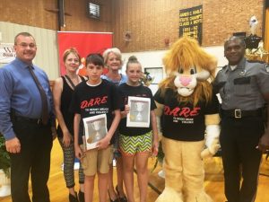 DeKalb West School Fifth Grade D.A.R.E. Graduation Essay Winners: Carter Vickers (Overall Winner) and Autumn Dies. Vickers received a $50 check from General Sessions and Juvenile Court Judge Bratten Cook, II presented in his absence by Tish Summers and Megan Cook. Pictured: Sheriff Patrick Ray, Megan Cook, Carter Vickers, Tish Summers, Autumn Dies, DAREN THE LION, and D.A.R.E. Instructor Lewis Carrick