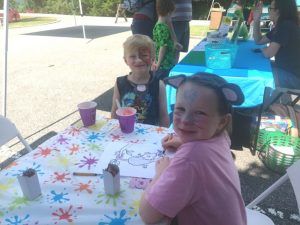 Heaven Leigh Angel Johnson and Justice Johnson coloring an outline of an opossum