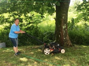 Ramona Hudson mowing lawn at residence on Highway 56 south