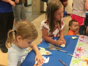 Children Coloring Paper Cutouts of Spaceships