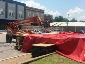 Repairs began to the Fiddlers Jamboree stage Friday after a storm blew through Thursday afternoon knocking down the canopy and the beams that supported it.