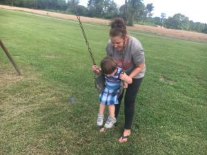 Amy Reed with Kayden Gammons at the swings in the Alexandria Children’s Playground Friday