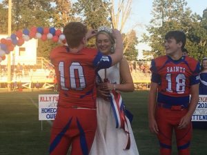 DeKalb Saints football captain Ari White crowns Homecoming Queen Allyson Roxanne Fuller with football captain Briz Trapp looking on during Thursday night’s pre-game Saints Homecoming program. White and Trapp were Fuller’s escorts.