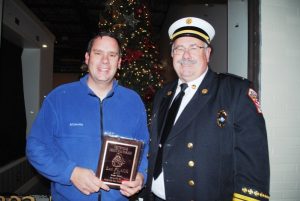 Smithville Deputy Fire Chief Hoyte Hale presents plaque to Casey Midgett of First Bank for winning 2nd place Float in the Smithville Christmas Parade Saturday evening