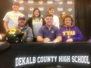 DCHS Football Senior Isaac Cross, surrounded by his family, signed a letter of intent Wednesday to play for the Tennessee Tech Golden Eagles next year after he graduates. Pictured left to right-seated Tony Cross (father), Isaac Cross, and Shelly Cross (mother). Back row: Eli Cross (brother), Ally Cross (sister), Silas Cross (brother), and Abby Cross (sister)