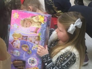 Youngster opens her gift bag and finds lots of surprises at Head Start Center Friday