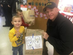 Smithville Police Chief Mark Collins presents bag of toys to youngster at Head Start