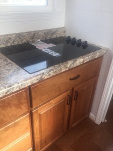 Tiny House Cooktop Stove in Kitchen with solid wood cherry cabinets