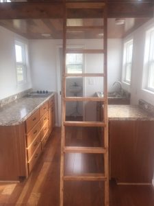 Tiny House kitchen area with solid wood cherry cabinets and cherry laminate flooring