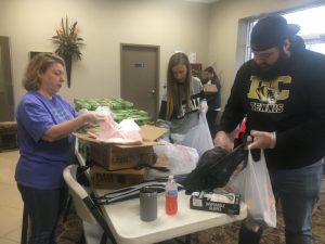 Tonya Jones, Amy Fricks, and Jordan Atnip preparing food bags at the Smithville First Baptist Church Life Enrichment Center for distribution to students in drive thru pickup line Monday.