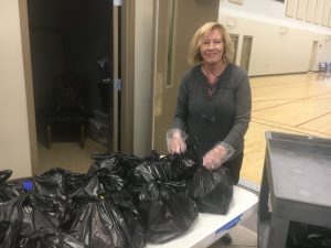 June Bilbrey preparing food bags for distribution to students