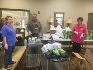 June Bilbrey, Tonya Jones, Bill Conger, and Brenda Hooper preparing food bags for distribution to students