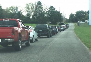 Those being served by the Snow Hill Baptist Church Food Ministry Sunday began lining up in their vehicles on Snow Hill Road near the church an hour before the scheduled drive thru pickup began