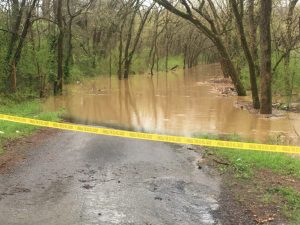 Road Supervisor warns public not to remove caution tape or cones across flooded county roads. Photo shows tape across impassable West Main Street in Dowelltown Sunday morning