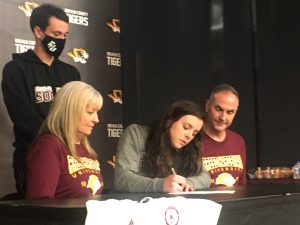 DCHS Lady Tiger Soccer Sensation Carly Vance Signed with Freed-Hardeman Thursday as her parents seated next to her Cheryl and Chris Vance and Freed-Hardeman Assistant Coach Luke Janiec look on