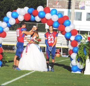 Escort Wyatt Carter , Saints 8th grade captain, crowns Addyson Grace Swisher Homecoming Queen Thursday night while Swisher’s other escort Hunter Buchanan, 8th grade captain, stands to the right