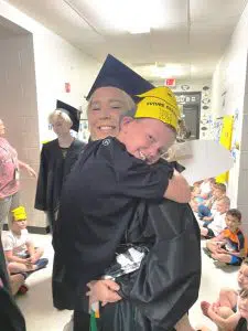 Kindergarten student Thomas Brelje hugs former DWS student and DCHS graduate Ally Beth Cook at the Senior Graduation Walk at DeKalb West School.