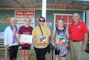 During Friday’s Official Fiddlers Jamboree Welcoming Program State Senators Janice Bowling (left) and Mark Pody (right) presented flags flown over the state capitol to Jamboree visitors who traveled the longest distances to get here. Tennessee State Flags went to Claire Morris of Memphis (second from Left) and Marymargaret Saldana of Denair, California (second from right) while a United States flag was presented to Christine Cordova of Uganda (center)