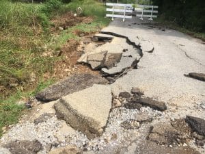 Members of the DeKalb County Highway Department have spent the last week repairing roads in the county damaged by recent flooding and the work will continue in the days ahead. Picture here shows damage on the Old Highway 53 near Alexandria. The road is now repaired