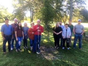 The DeKalb County Soil Conservation District paid tribute to the late Anita Houk Wednesday morning by planting a Sunset Maple tree in her memory at Green Brook Park. Pictured left to right are members of her family at the ceremony: Tommy Melton, Danny Curtis, Taylor Patterson, Deborah Agee, Mary Melton, Bernard Houk, Jennifer Winchester, Jason Winchester, Delilah Barrett, Sonny Barrett, and Justin Winchester