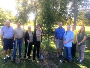 The DeKalb County Soil Conservation District paid tribute to the late Anita Houk Wednesday morning by planting a Sunset Maple tree in her memory at Green Brook Park. Pictured left to right are leaders and employees of the DeKalb Soil Conservation District: Jimmy Womack, Zach Fuson, Judy Sandlin, Genrose Davis, Jimmy Herndon, Gene Robinson, Pamela Hale, and Melissa Oliver.