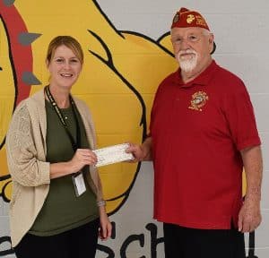 Photo: DWS Principal Sabrina Farler received a $200 donation from John Hummer of the Bobby Ray Detachment 1377 of the Marine Corps League.