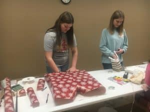 Kids wrapping Christmas Gifts for parents and caregivers at Saturday's 8th annual Regifting Event