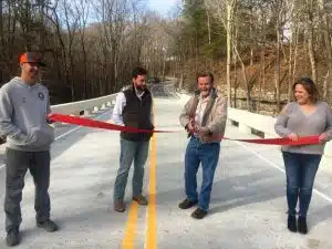 Now Open! After seven months, motorists traveling Big Rock Road no longer have to detour because the new bridge over Pine Creek is now completed. Road Supervisor Danny Hale held a ribbon cutting at the bridge in December accompanied by his secretary Rena Willoughby; the Project Engineer, Kyle Hazel of Hazel Engineering, LLC in Cookeville (pictured far left); and Project Manager Justin Garmany of Dement Construction in Jackson (pictured second from left).