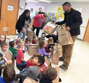 Children at the Smithville Head Start Center last month were treated to bags of gifts thanks to the Smithville Police Department’s “Cops4Kids” program. Detective Brandon Donnell shown here presenting gift bags to kids