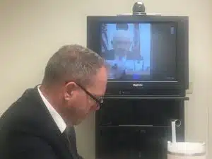 Parole Board Chairman Richard Montgomery presided over the parole hearing for Albert Fisher Tuesday. The hearing was held at the prison in Nashville where Fisher is incarcerated. Assistant District Attorney General Greg Strong participated in the hearing by video conference from Cookeville. Strong is shown here with a TV screen in the background showing Parole Board Chairman Montgomery