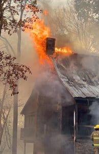 A Sunday afternoon fire destroyed one home, heavily damaged another, and charred five acres of woodlands in the Cove Hollow Community off Dale Ridge Road. (Jim Beshearse Photo)