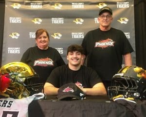 Outstanding senior defensive lineman Wil Farris, who blazed a trail over his award winning four year football career at DCHS, will be aiming to do the same starting next season at the college level. Accompanied by members of his family, coaches, and fellow Tiger football players at DCHS, Farris signed a letter of intent Monday with Cumberland University in Lebanon to play for the Phoenix. Pictured here with his grandparents, Kathy and Bruce Chapman.