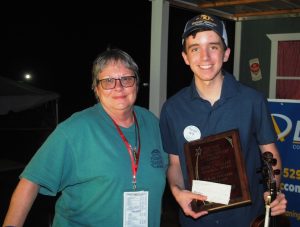 Noah Goebel, a 14-year-old fiddler from Elkton, Kentucky, will be representing the Smithville Fiddlers’ Jamboree at the Grand Ole Opry to play a lively ‘fiddle tune’ for the Opry Square Dancers. Noah will be performing this Saturday, May 25th, 2024.. Pictured here with Kim Luton, President and Coordinator of the Smithville Fiddlers Jamboree and Crafts Festival