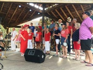 The Community Chorus headlined a Jamboree celebration kick-off patriotic program Thursday evening at Evins Park downtown joined by five-square dance teams, Smithville Select, DeKalb Dancin’ Delights, Center Hill Hoedown, Ragland Bottom Roundup, and Caney Fork Circle Eights led by Mary Ann Puckett.