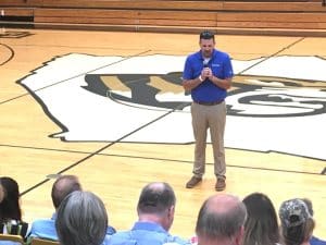 Lifting up schools in prayer! A community gathering was held at the high school Sunday to offer up prayers for all those affiliated with the school system in what has become an annual observance prior to the start of school. Chad Ramsey of the Smithville First Baptist Church shown here praying for extracurricular activities/athletics