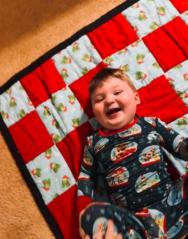 PatchWork UC blessed 4 DeKalb County residents with quilts this year. 3 were made from blocks that children created at the 2024 Regifting Event. The 4th was a handmade donated lap quilt. Greyson James, loving his quilt